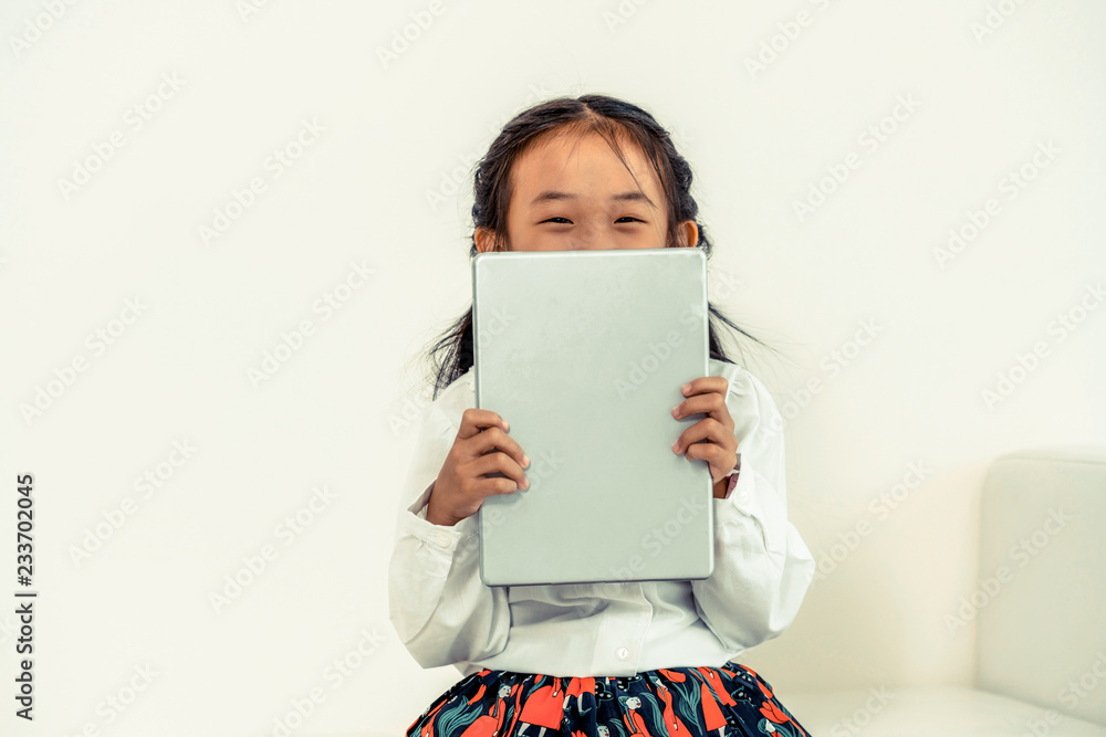 Little happy kid on white background with tablet computer. Childhood lifestyle.