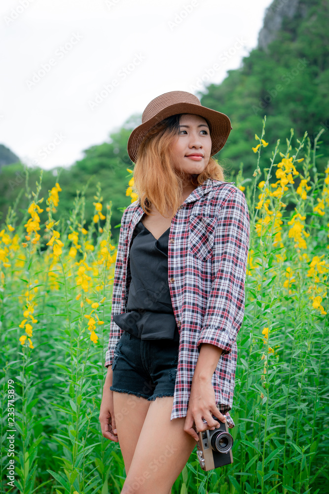 年轻女子在相扑户外自然景观中旅行时，手里拿着复古风格的相机