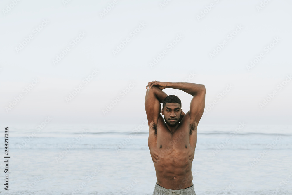 Fit man stretching at the beach