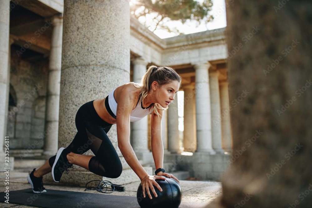 Female athlete doing workout using a medicine ball