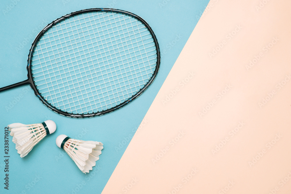 Shuttlecock and racket for playing badminton on a pástel color background. Minimalism. Concept summe