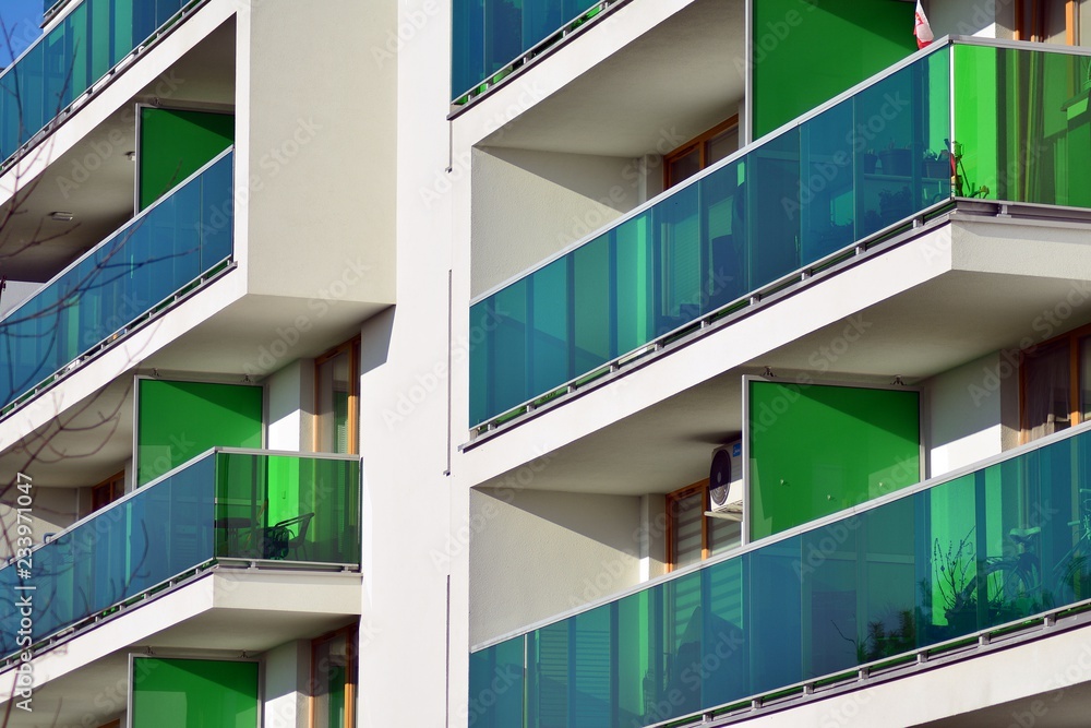 Fragment of a facade of a building with windows and balconies. Modern home with many flats.