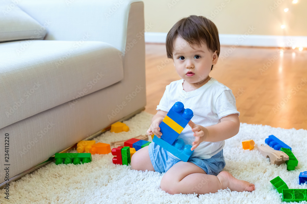 Little toddler boy playing with his toys