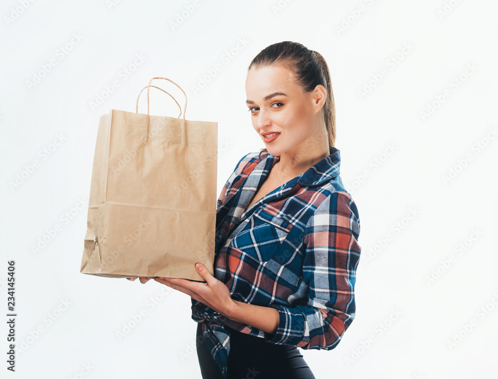 Portrait of a pretty woman hold shopping bag. Female model in a nice stylish shirt with packet isola