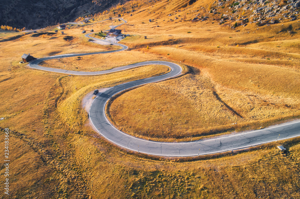 日落时分，山脉中秋林中蜿蜒道路的鸟瞰图。完美沥青的俯视图