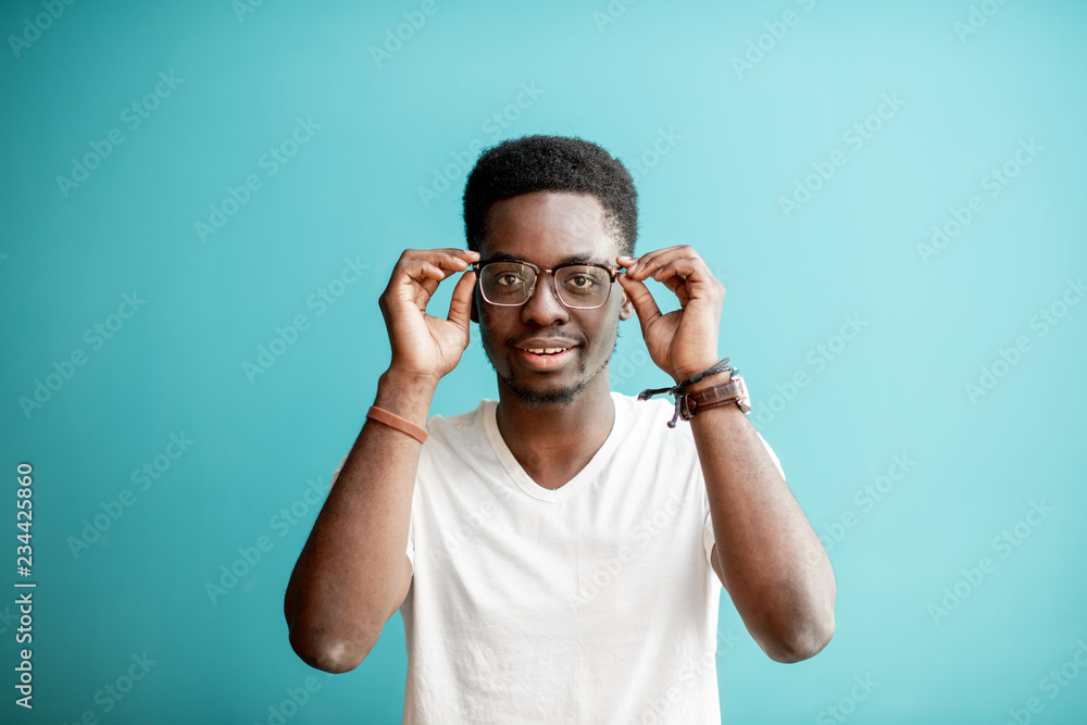 Portrait of a young african man dressed in white t-shirt standing on the colorful background