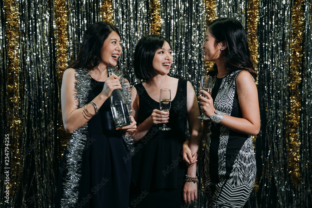 young asian girls holding bottle of wine