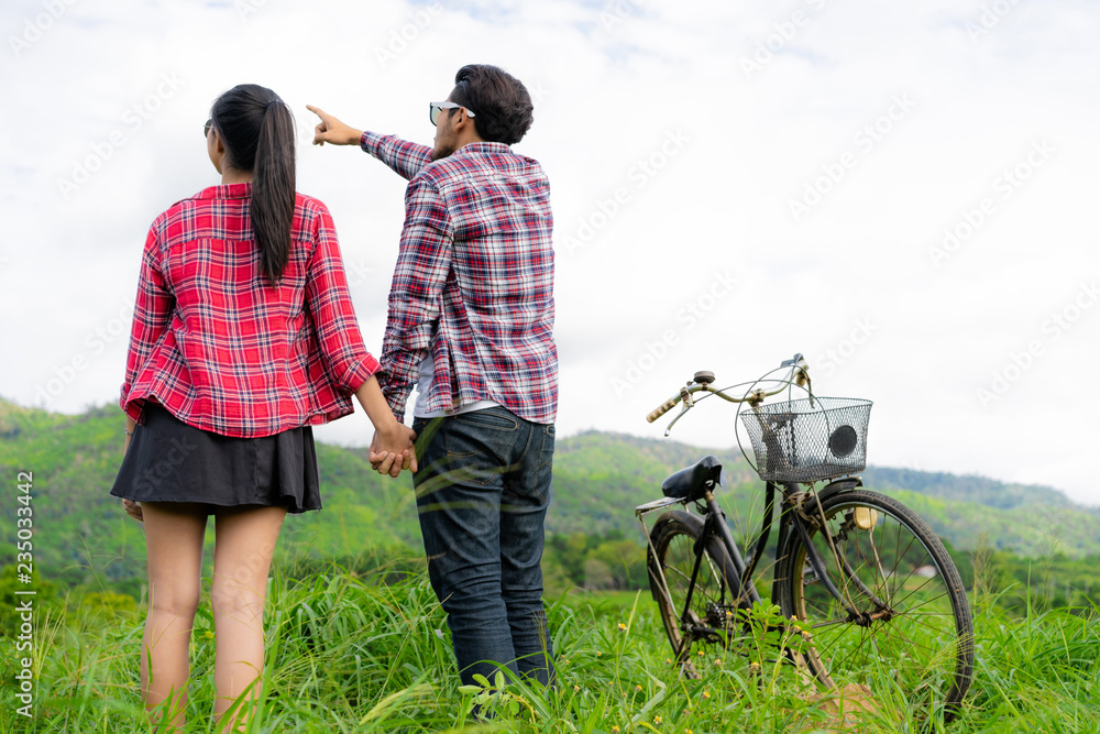 Happy young couple ride bicycle on the hills.