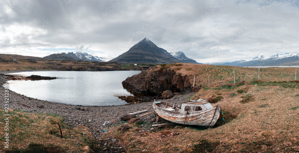 Typical Iceland landscape with fjord, mountains and old ship