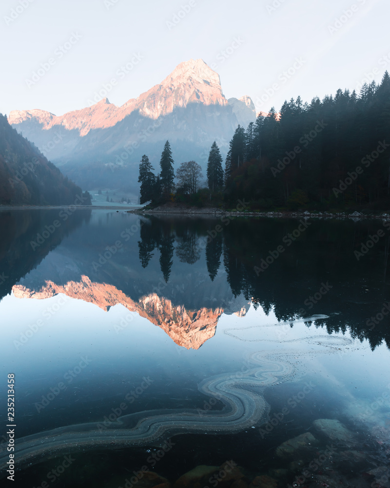 瑞士阿尔卑斯山奥伯西湖上宁静的秋景。晴朗的天空和群山在清澈的海水中倒影