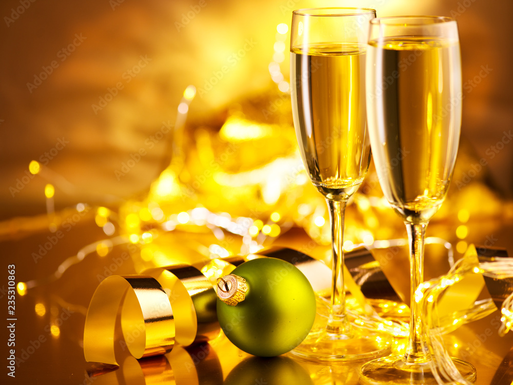 Christmas scene. Holiday champagne over golden glow background. Christmas and New Year celebration. 