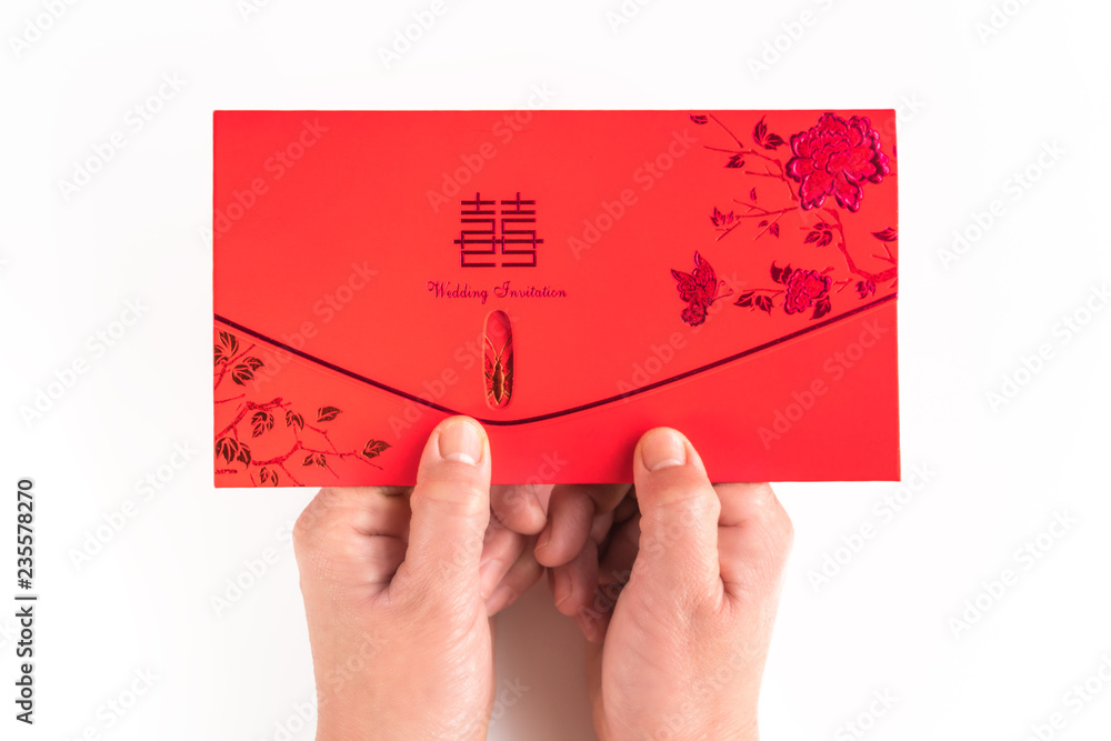 A close-up of the invitation in white background with both hands