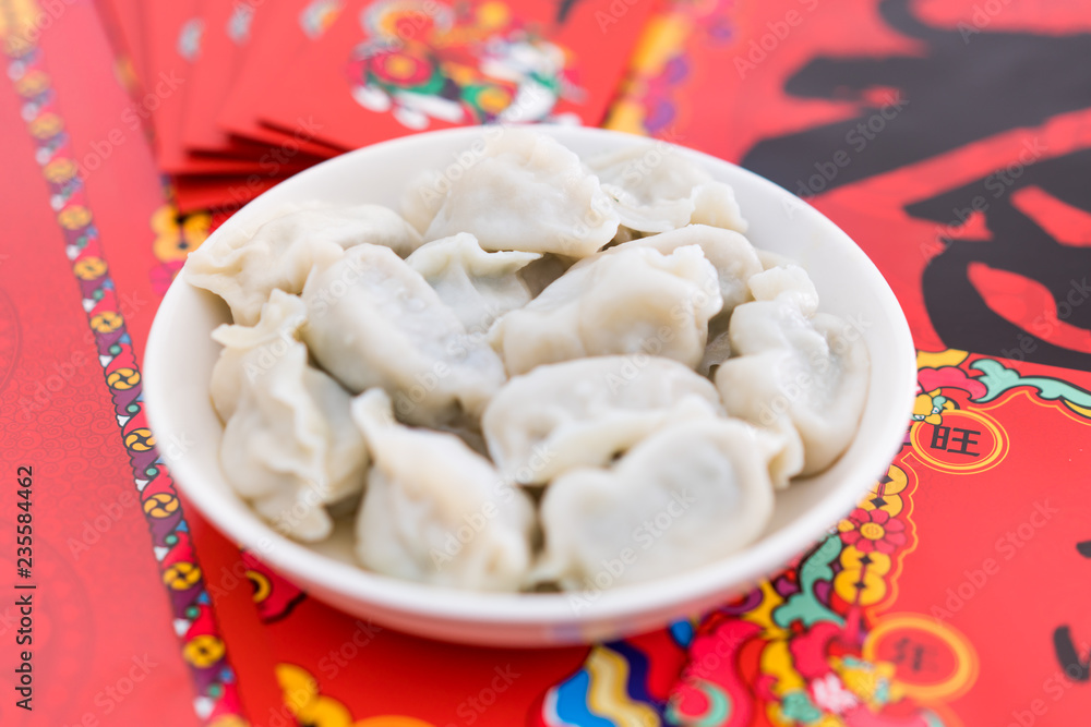 A dish of dumplings under the background of red couplets during the Spring Festival