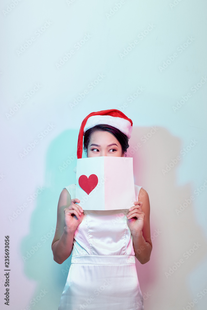 Image of happy beautiful female reading romantic postcard with big red heart, attractive woman got s