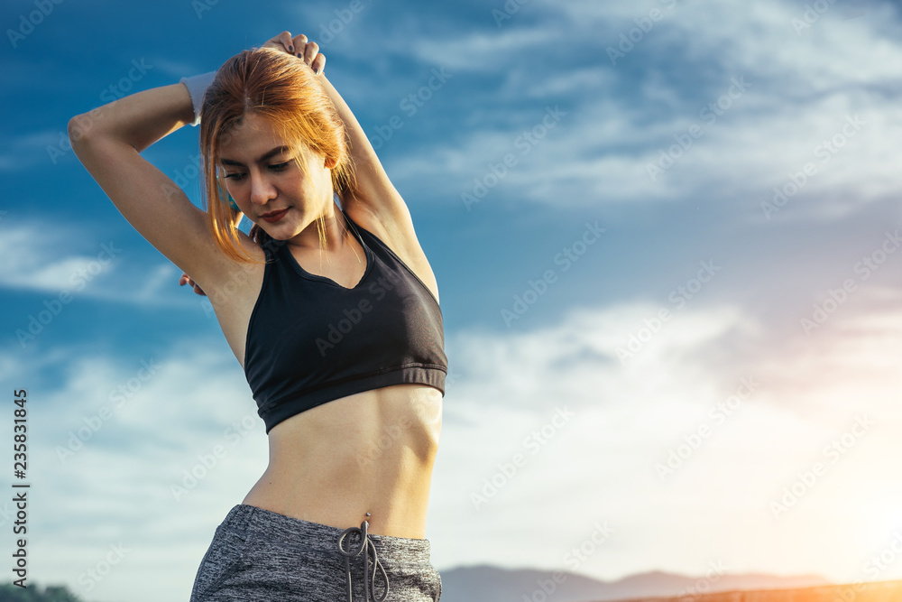 Asian woman is workout and running at the morning, she is warm up her body and drinking water. Healt