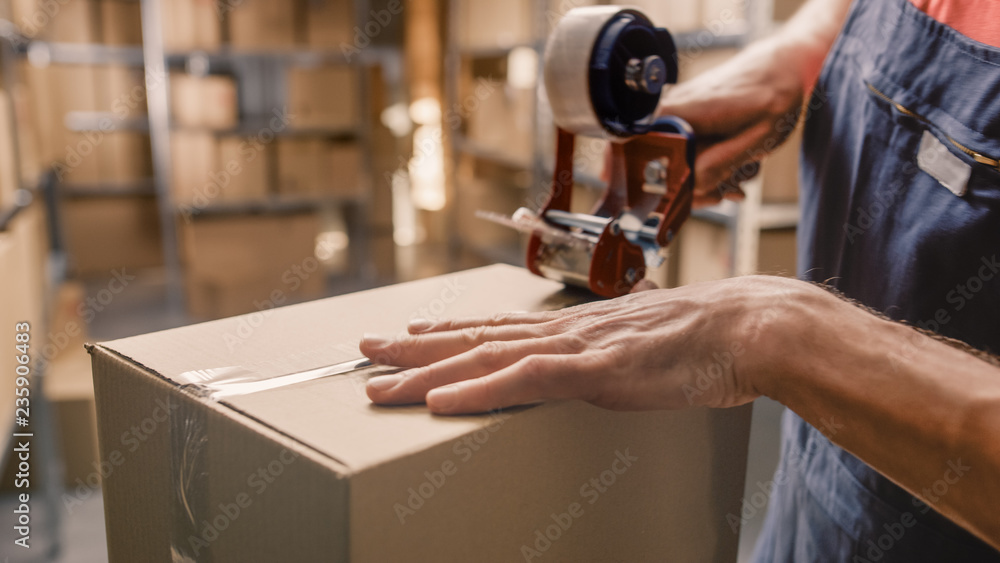 Warehouse Worker Checks and Sealing Cardboard Box Ready for Shipment. 