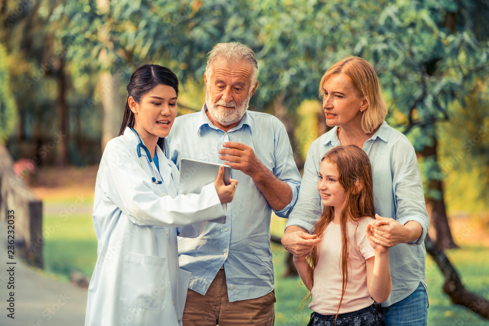 Happy healthy family and doctor talking in the park. People healthcare and medical staff service con