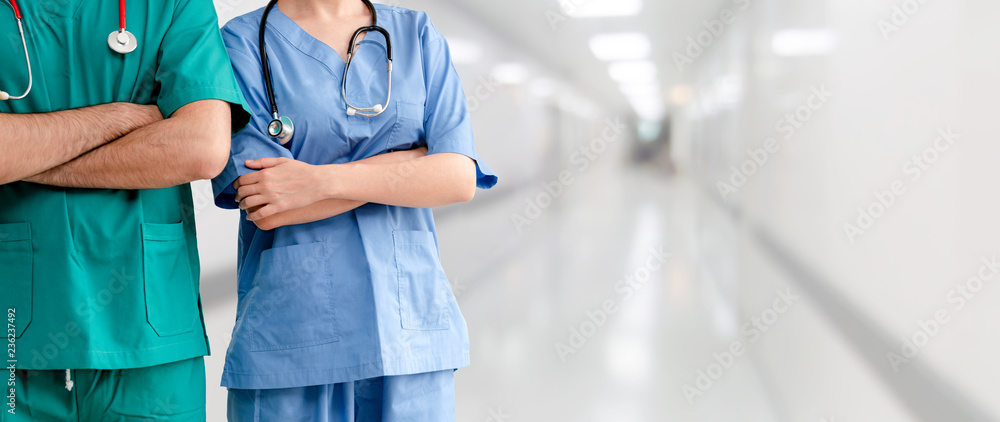 Two hospital staffs - surgeon, doctor or nurse standing with arms crossed in the hospital. Medical h