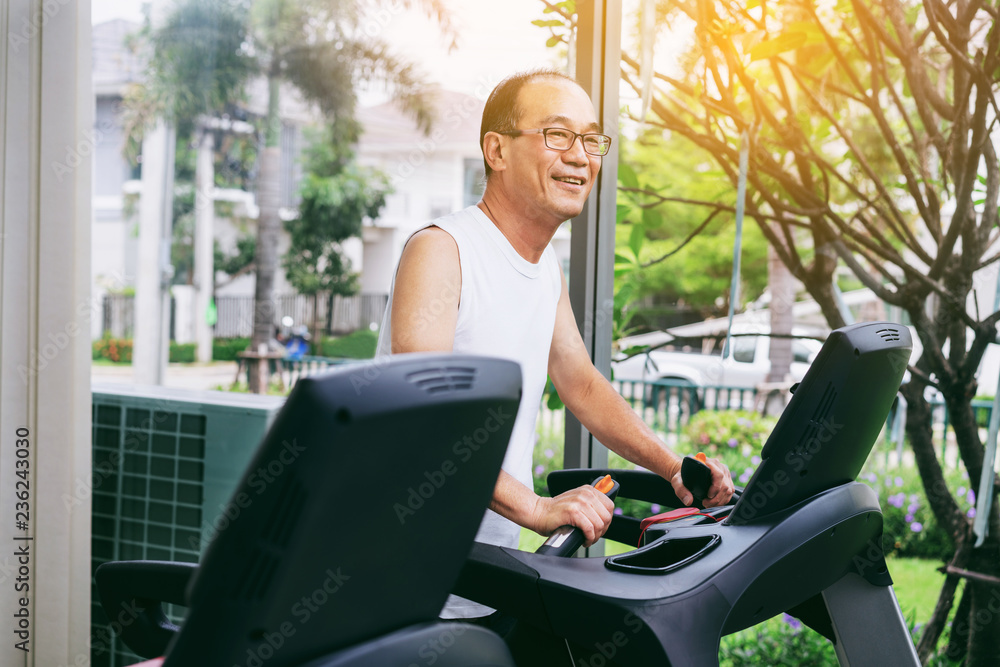 Senior man exercise on treadmill in fitness center. Mature healthy lifestyle.