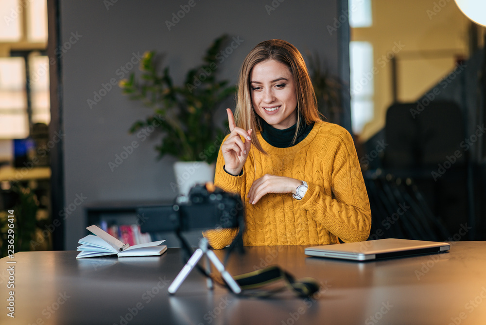 一位年轻女士正在录制她的每日视频博客。