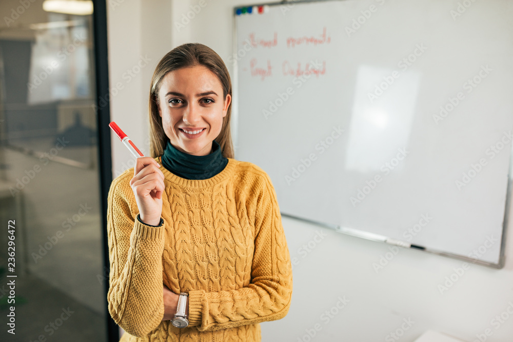 带马克笔的快乐年轻商业女性肖像。