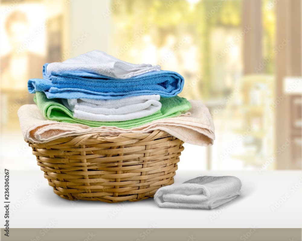 Laundry Basket with colorful towels on background