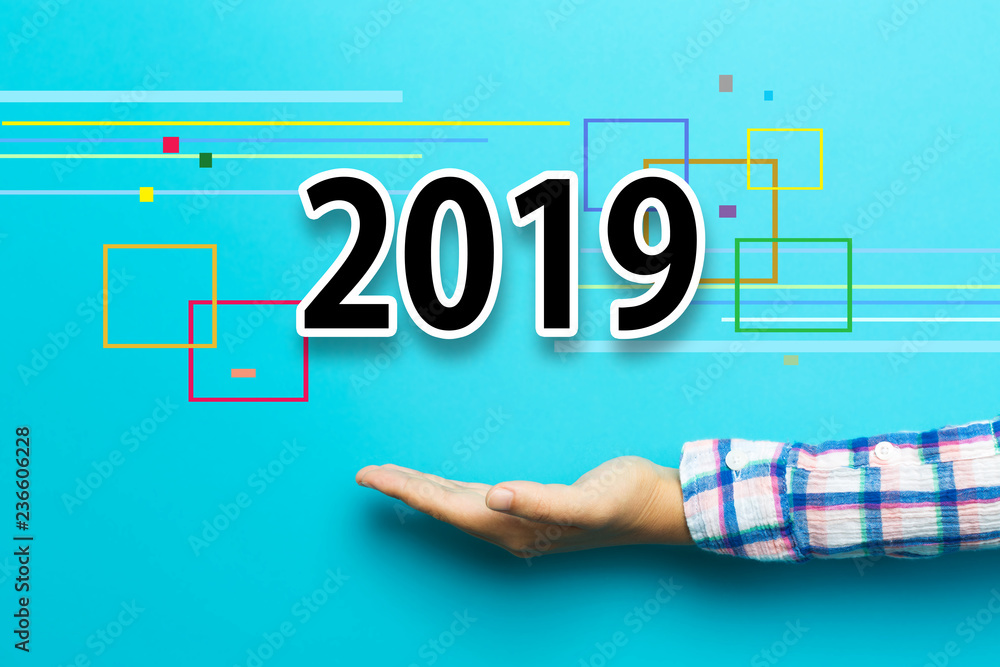 2019 new year concept with hand on blue background