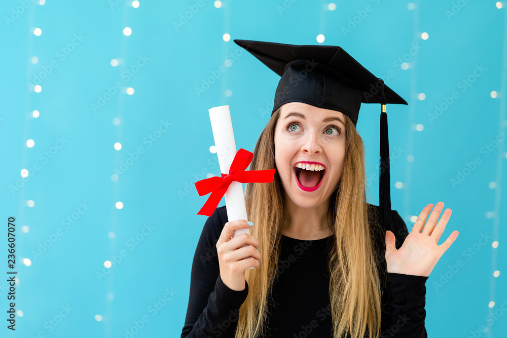 Young woman with a graduation diploma on a shiny light background