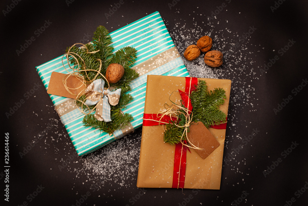 Flat-lay of two Christmas presents with some snow flakes and nuts