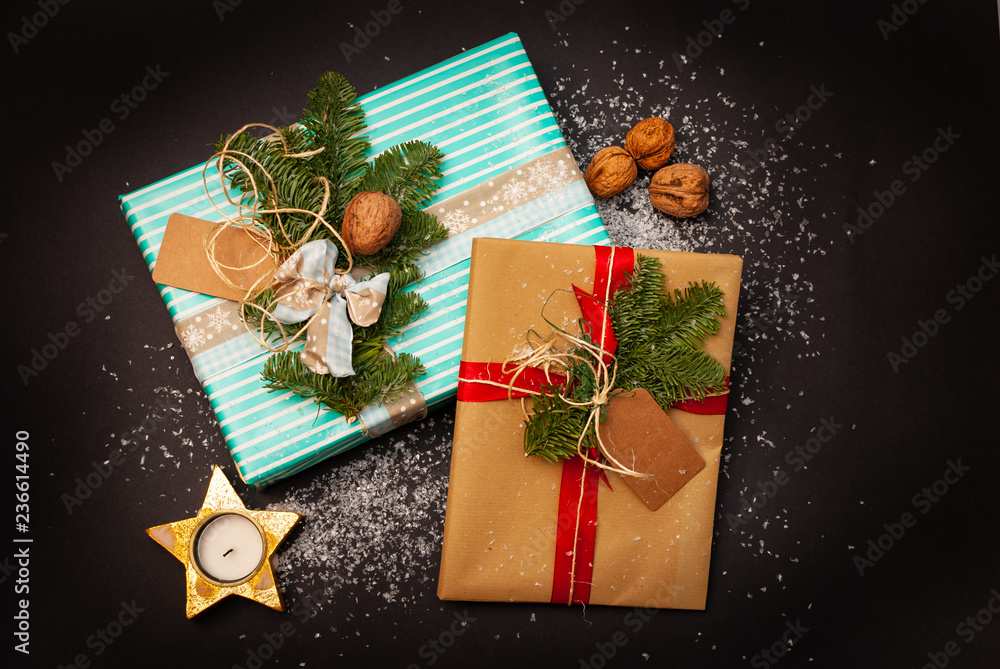 Flat-lay of two Christmas presents with some snow flakes and nuts and stars