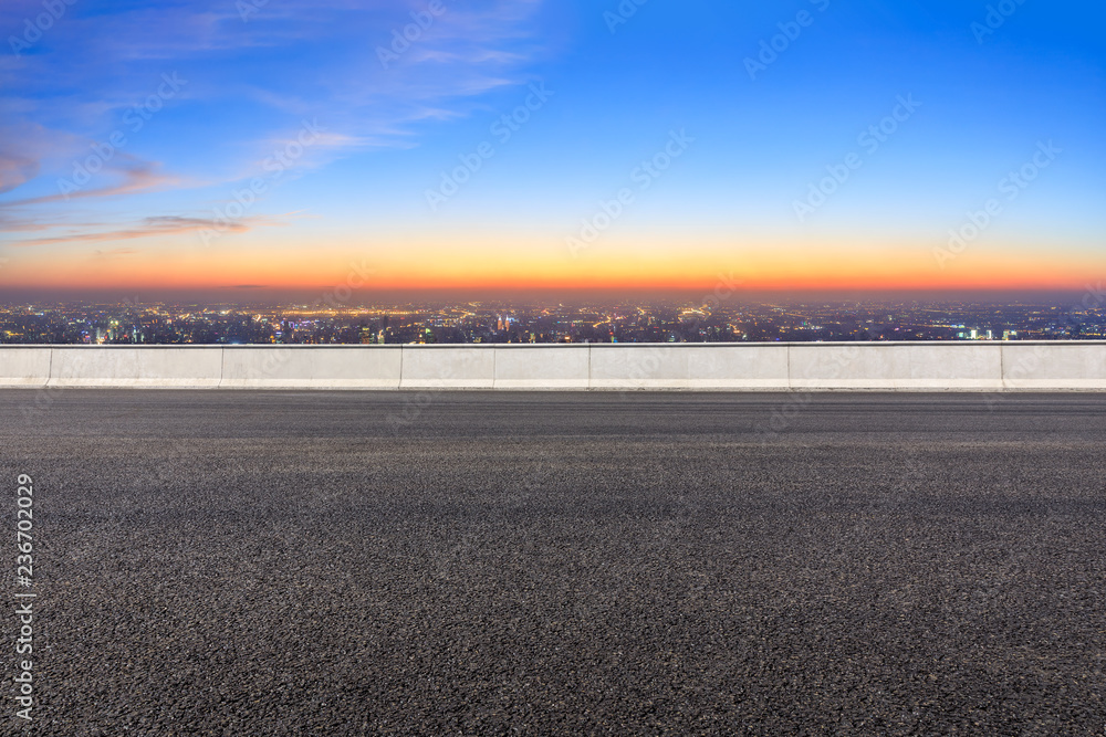 空旷的柏油路和夜晚的现代城市天际线