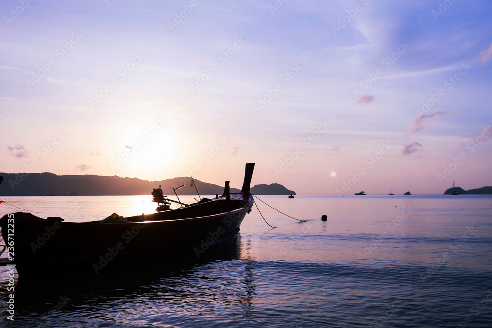 fishing boat or longtail boat in the sea in morning time with beautiful sunrise and reflection in th