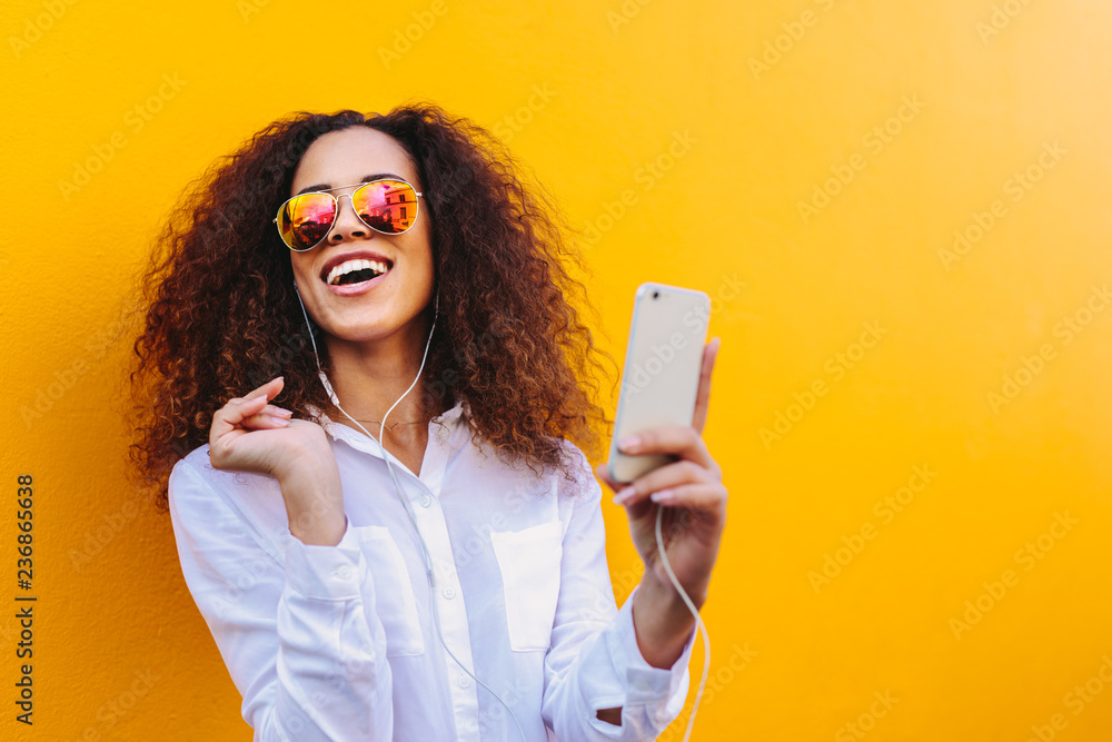 Happy african woman listening to music