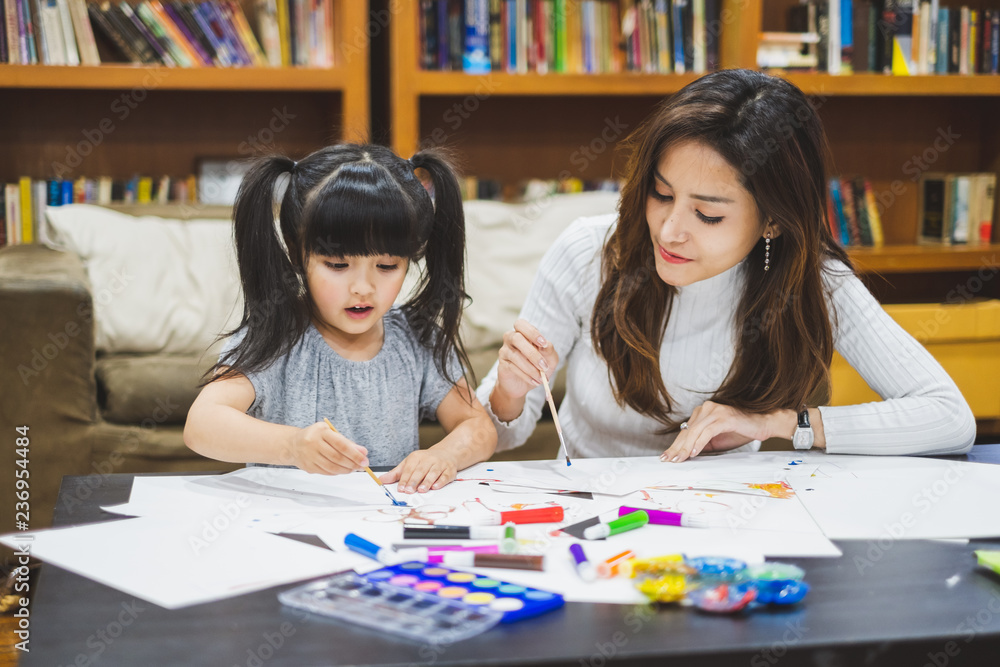 Asian girl kid and mother doing drawing with many colour pencils on white paper