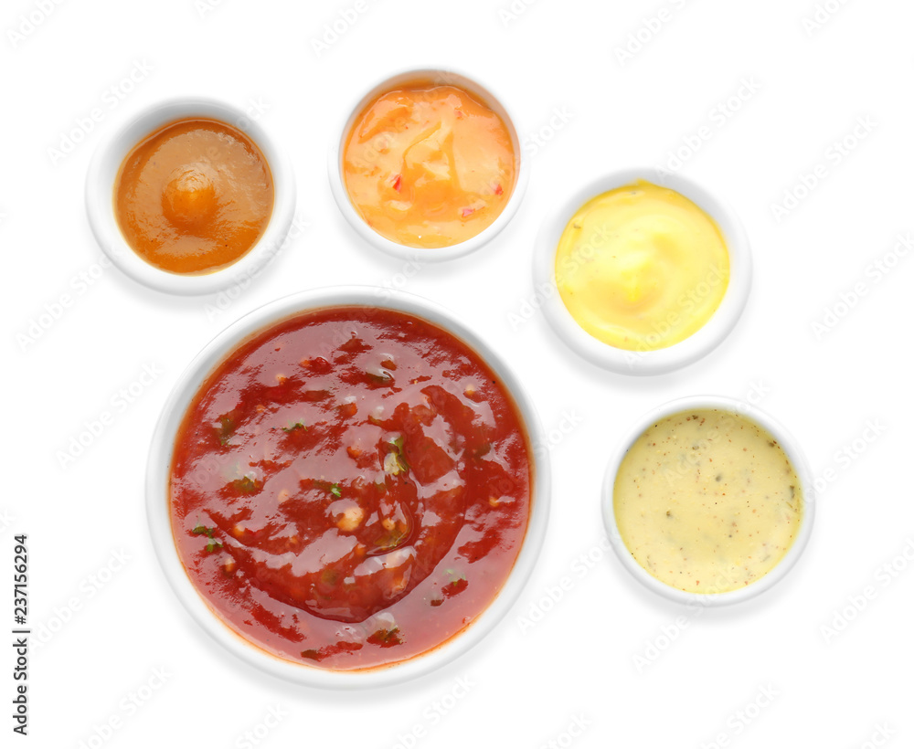 Different tasty sauces in bowls on white background