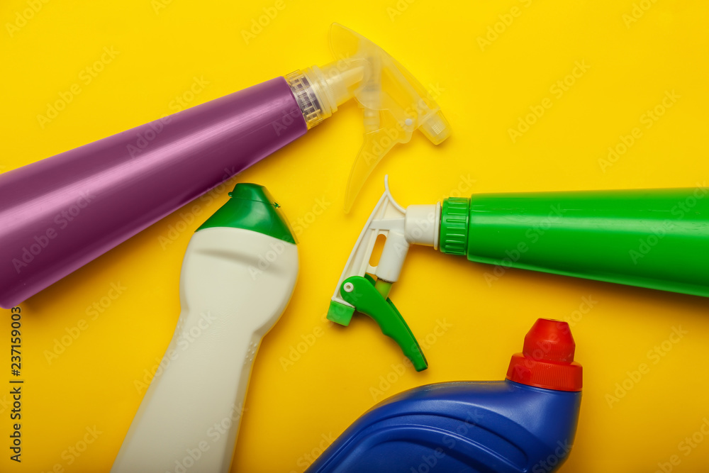 Bottles of detergent on color background, top view