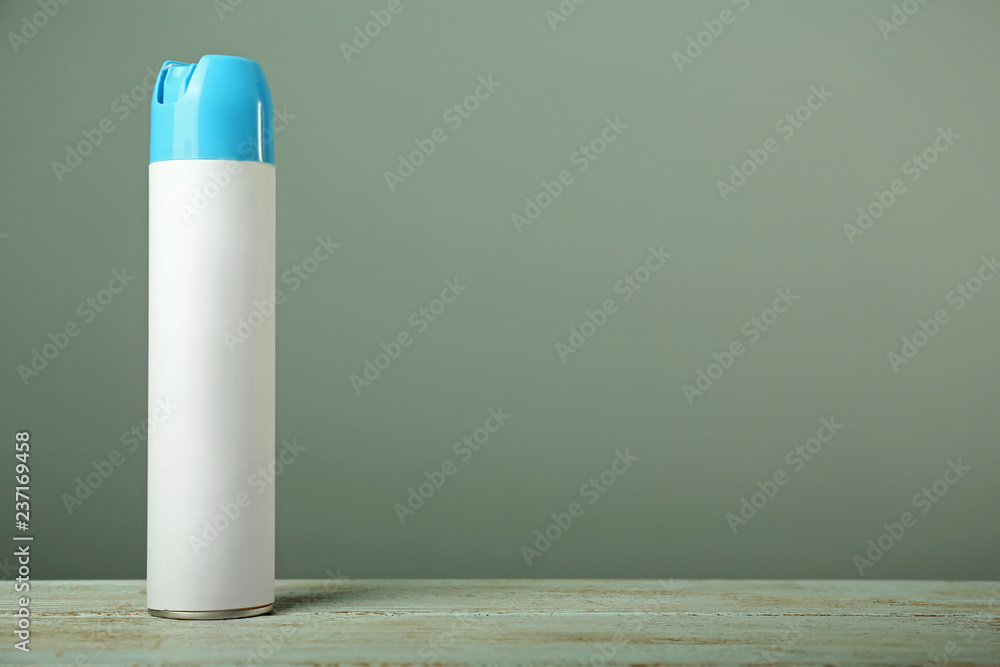 Air freshener on wooden table against grey background