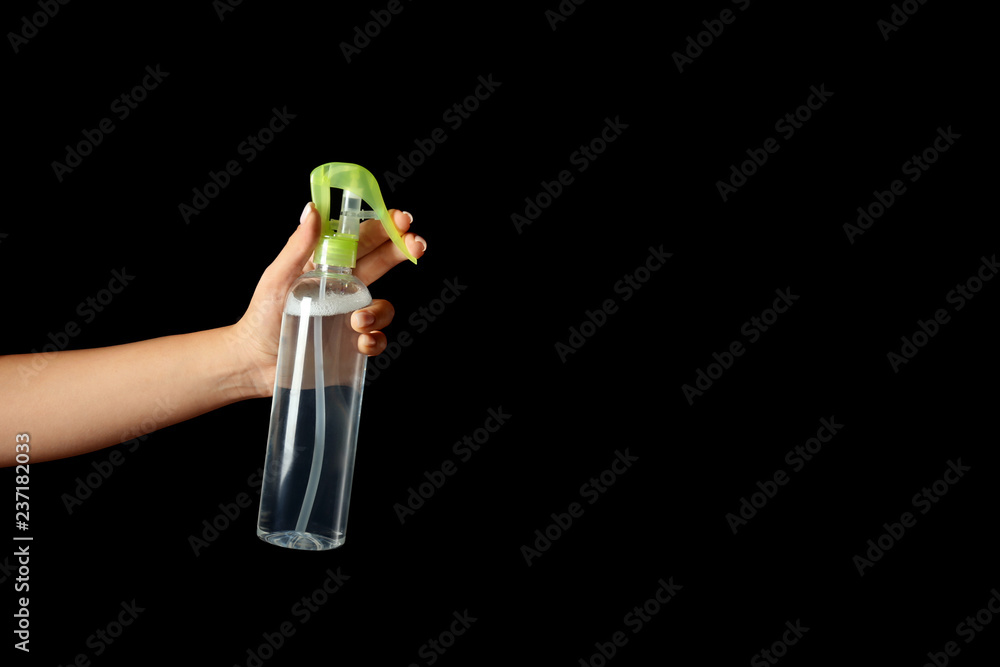 Woman holding air freshener on dark background