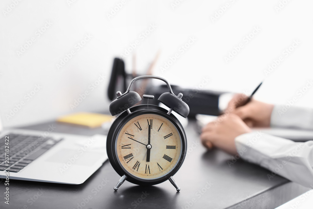 Alarm clock on dark table in office