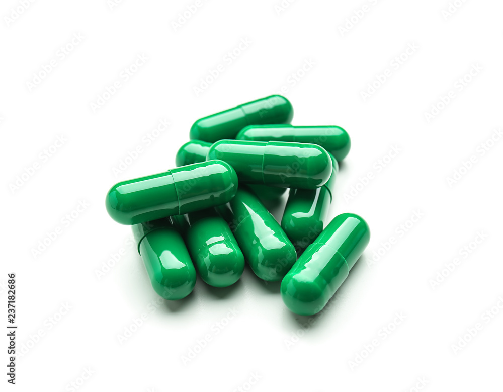 Spirulina capsules on white background