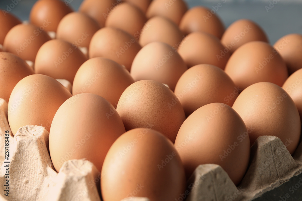 Raw chicken eggs in carton pack, closeup