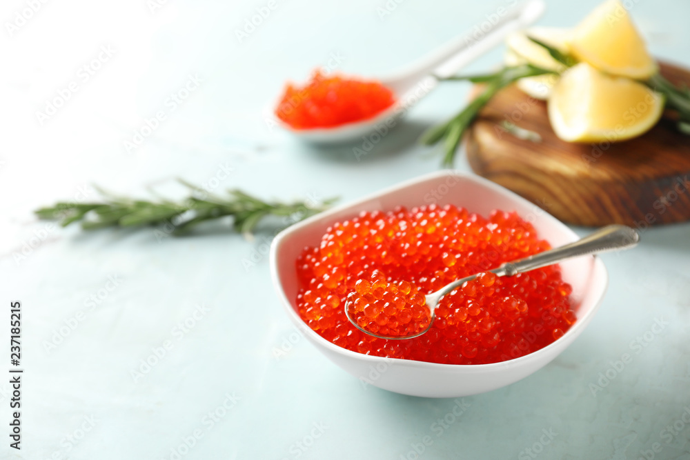 Bowl with delicious red caviar on light table