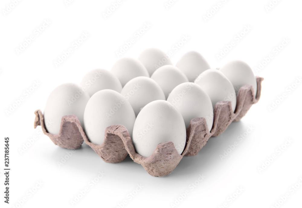 Carton pack with raw chicken eggs on white background