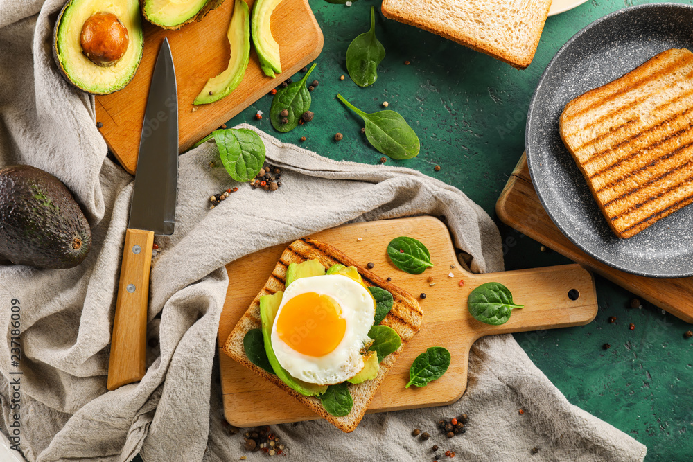 Toasted bread with tasty fried egg on color background