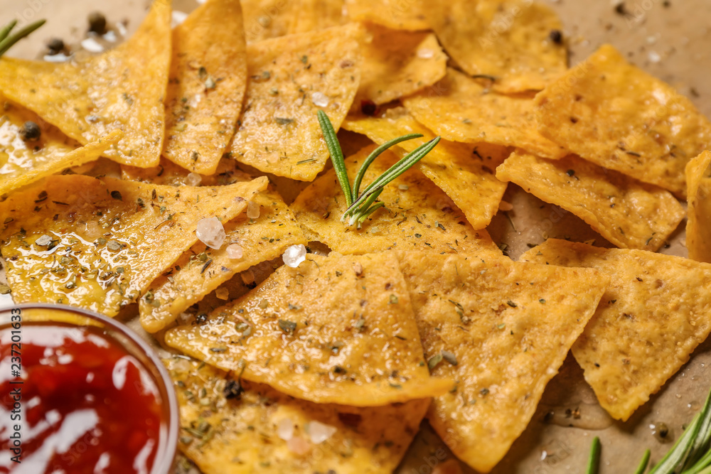 Tasty corn chips with sauce on parchment