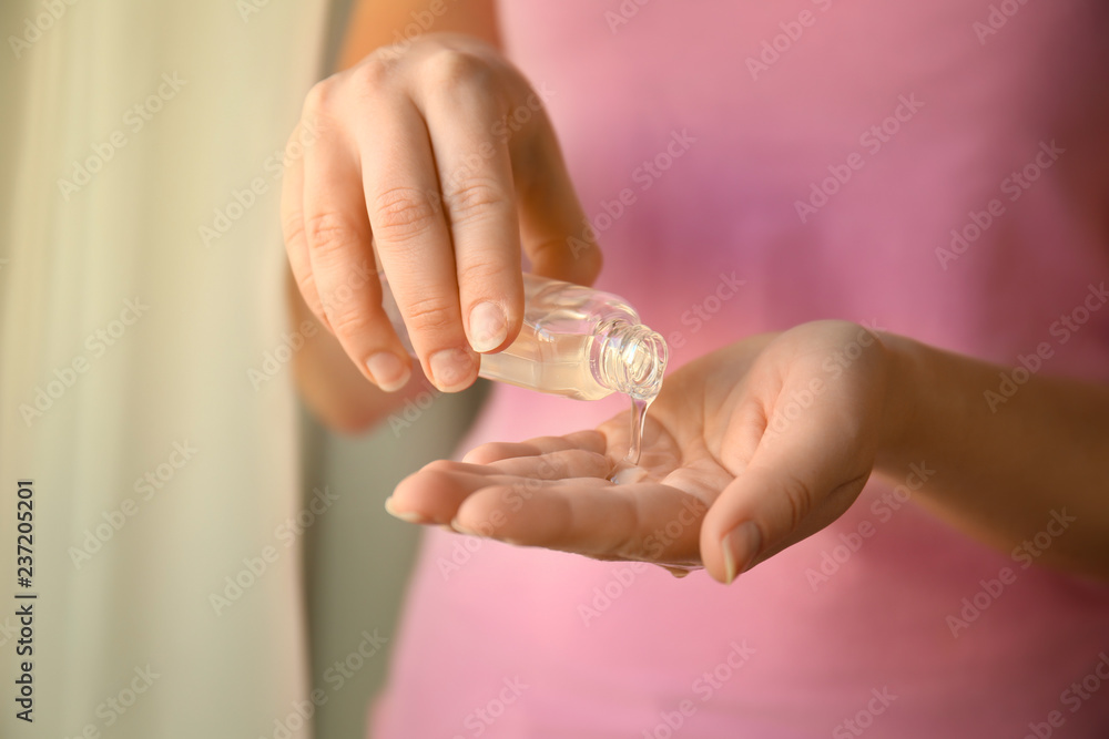 Woman using antibacterial hand gel, closeup