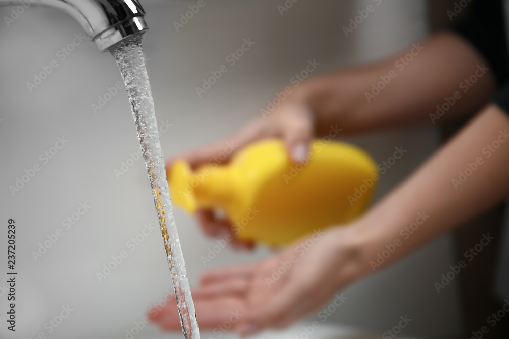 Woman washing hands in bathroom