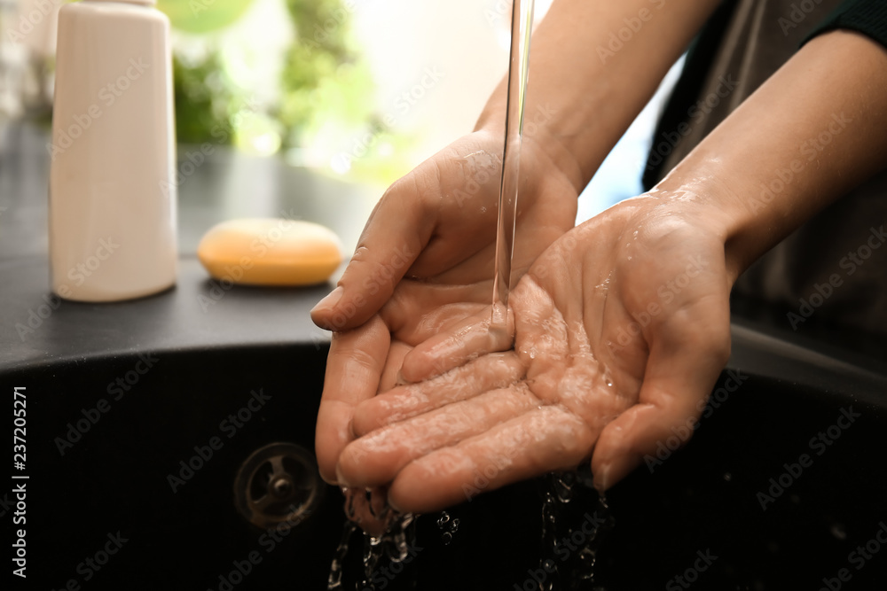 Woman washing hands in bathroom