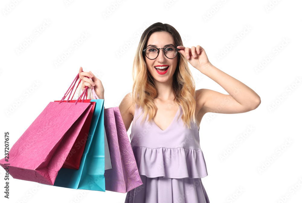 Beautiful young woman with shopping bags on white background