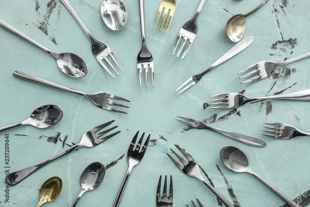 Spoons and forks on color background, flat lay